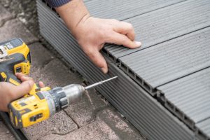 Salem worker assembling composite deck using cordless screwdriver