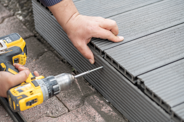 Salem worker assembling composite deck using cordless screwdriver